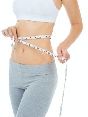 Cropped studio shot of a woman measuring her waist with a measuring tape -Isolated image